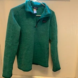 Teal women’s Patagonia 1/4 zip pullover with arm zipper pocket on left sleeve